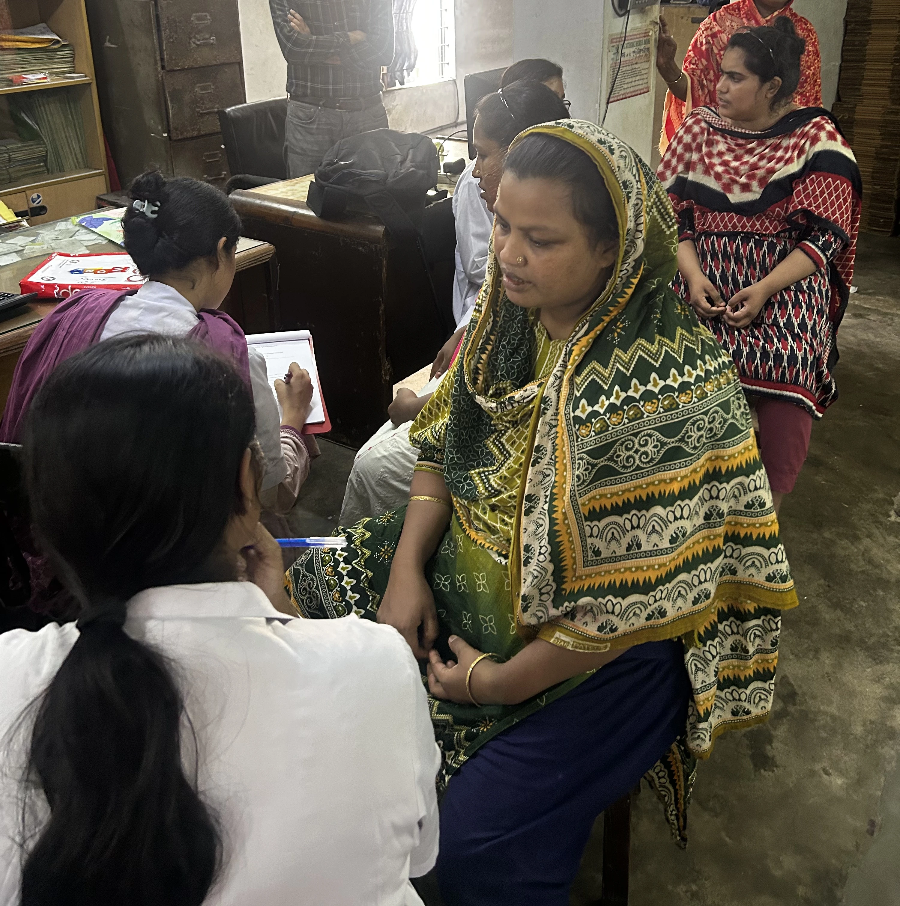 Medical staff performing a clinical breast exam during a factory screening camp